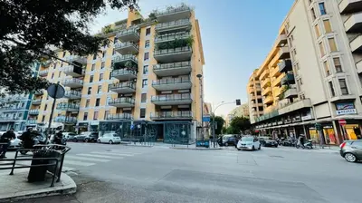 a city street with cars parked in front of a building at wood & white home in Palermo