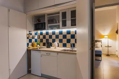 a kitchen with white cabinets and blue and white tiles at Casa Madì in Palermo