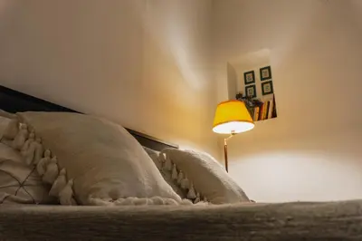 a bed with a blanket and a lamp next to it at Casa Madì in Palermo