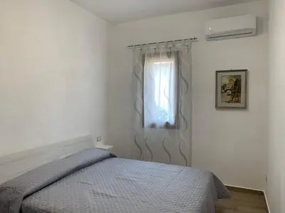 a bedroom with a bed and a window at La Villa degli Ulivi - Apartments in Castellammare del Golfo