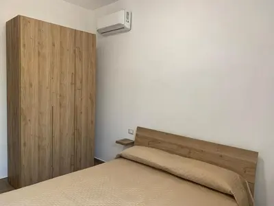 a bedroom with a bed with a wooden headboard at La Villa degli Ulivi - Apartments in Castellammare del Golfo
