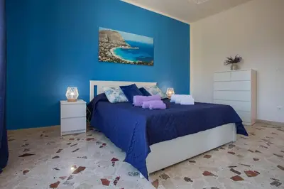 a blue bedroom with a bed and a blue wall at Sea Air - Aria di Mare in Casteldaccia