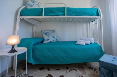 a bedroom with two bunk beds and a lamp at Sea Air - Aria di Mare in Casteldaccia