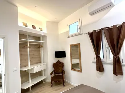 a room with white shelves and a mirror and a chair at Sikelia Apartment Centro in Palermo