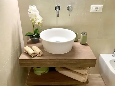 a bathroom with a bowl sink on a wooden counter at Sikelia Apartment Centro in Palermo