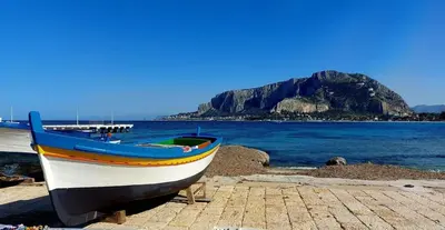 a boat sitting on a beach next to the water at Mondello Blue Sea in Mondello