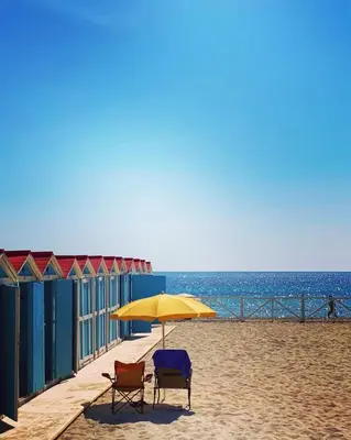 two chairs and an umbrella on the beach at Mondello Blue Sea in Mondello