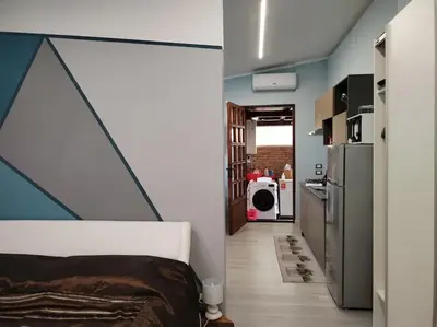a room with a bed and a hallway with a kitchen at Loft 2 in Mondello beach Mt. 200 from sea. in Palermo