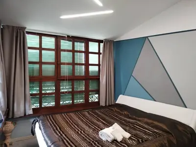 a bedroom with a bed with a large window at Loft 2 in Mondello beach Mt. 200 from sea. in Palermo