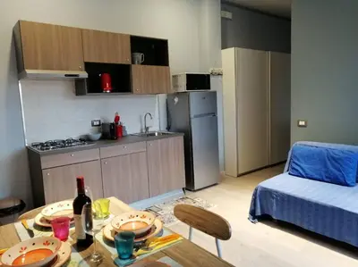 a room with a table and a kitchen with a bed at Loft 2 in Mondello beach Mt. 200 from sea. in Palermo