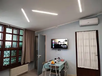 a dining room with a table and a tv on the wall at Loft 2 in Mondello beach Mt. 200 from sea. in Palermo