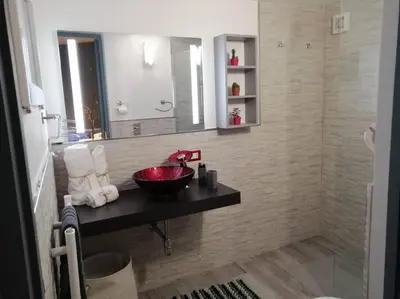 a bathroom with a red sink and a mirror at Loft 2 in Mondello beach Mt. 200 from sea. in Palermo