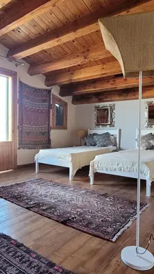 a living room with two beds and a rug at Villa Jesabel in Scopello