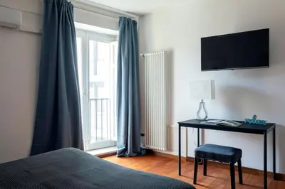 a bedroom with a bed and a desk with a television at Vicolo Paternò Apartments in Palermo