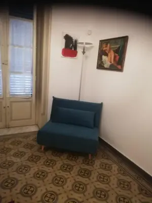 a blue chair sitting in a room next to a door at Amari 106 in Palermo