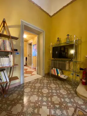 a living room with a tv on a yellow wall at Amari 106 in Palermo