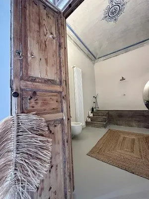 a bathroom with a wooden door and a toilet at Casa Guilla_alla Cattedrale in Palermo