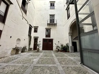 an empty courtyard with a building with a door at Casa Guilla_alla Cattedrale in Palermo