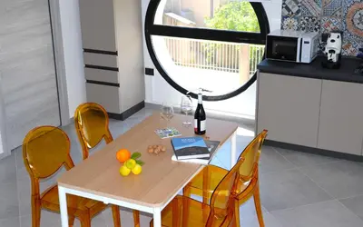 a dining room table with a mirror and a table and chairs at Elimi Home Appartamenti in Nuova Gibellina