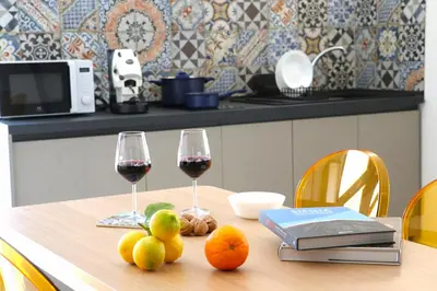 a table with two glasses of wine and fruit on it at Elimi Home Appartamenti in Nuova Gibellina