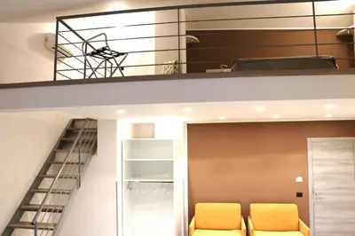 a loft bed with yellow chairs in a room at Elimi Home Appartamenti in Nuova Gibellina