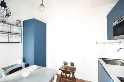 a kitchen with blue cabinets and a table at iFlat agli Archetti del centro in Palermo