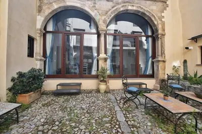 a courtyard with benches and a building with windows at iFlat agli Archetti del centro in Palermo