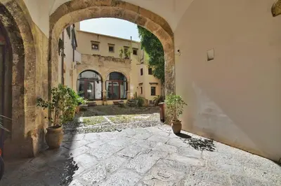 an archway in a building with two potted plants at iFlat agli Archetti del centro in Palermo