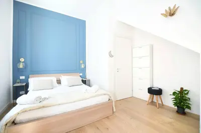 a bedroom with a large bed with a blue wall at iFlat Casa Isabella in Palermo