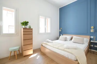 a bedroom with a large bed with a blue wall at iFlat Casa Isabella in Palermo