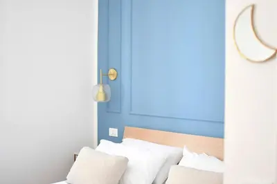 a bed with white pillows and a blue wall at iFlat Casa Isabella in Palermo