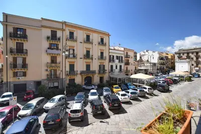 a parking lot with cars parked in front of buildings at iFlat Casa Isabella in Palermo