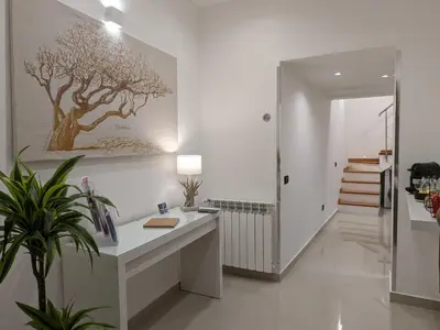 a white room with a desk and a painting on the wall at Iverlid Home. in Palermo